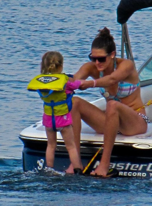 A child learning how to wakeboard and waterski for the first time.